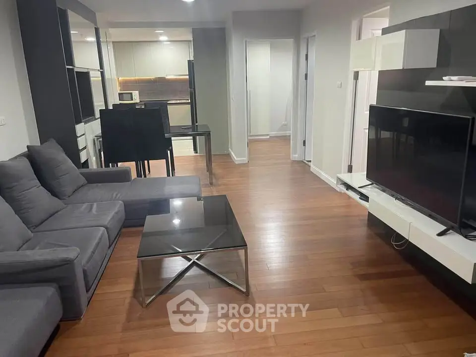 Spacious modern living room with sleek furniture and open kitchen layout, perfect for contemporary living.