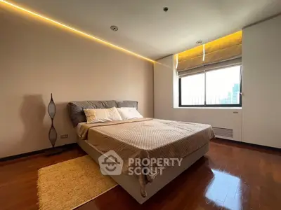 Spacious bedroom with modern design and city view, featuring a cozy bed and elegant lighting.