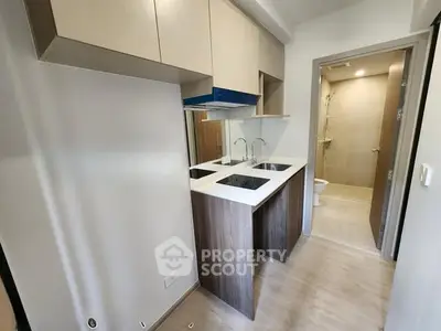 Modern compact kitchen with sleek cabinetry and adjacent bathroom