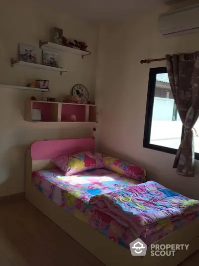 Cozy and inviting child's bedroom with a comfortable bed, playful bedding, and charming wall shelves filled with toys and books, perfect for a young family's home.