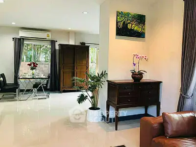 Spacious living room with elegant decor and natural light, featuring a dining area and stylish furniture.