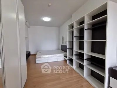 Spacious bedroom with modern shelving and wooden flooring