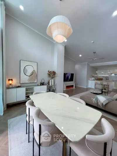 Elegant open-plan living and dining area with modern decor and stylish lighting