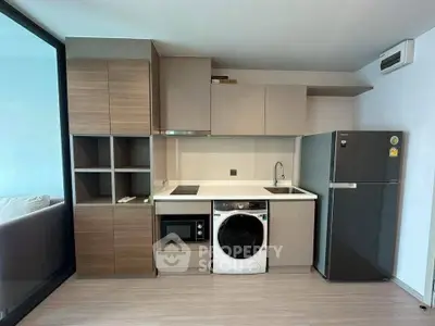 Modern kitchen with sleek cabinetry, built-in appliances, and washing machine in stylish apartment.