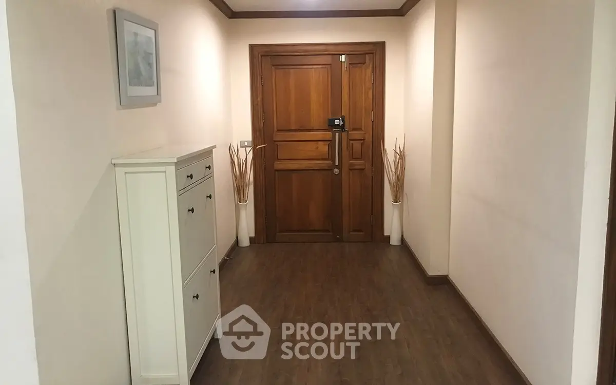 Elegant apartment entrance with wooden door and stylish decor
