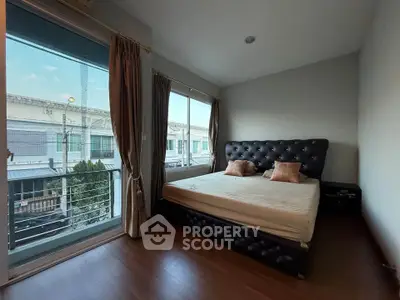 Spacious bedroom with large windows and modern decor, offering a serene view.