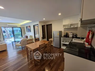 Spacious open-plan living room and kitchen with modern furnishings and wooden flooring.