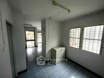 Spacious apartment interior with tiled floors and large windows for natural light.