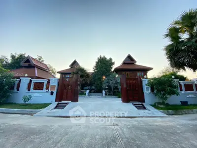 Stunning traditional-style home with grand entrance and lush greenery, perfect for serene living.