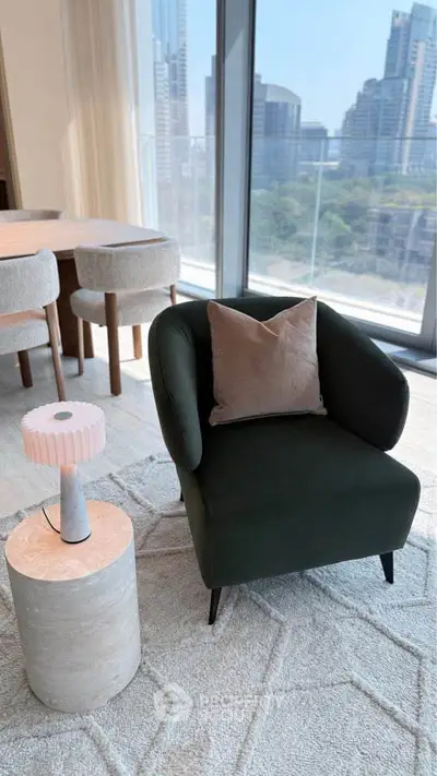 Stylish modern living room with city view, featuring elegant armchair and chic decor.