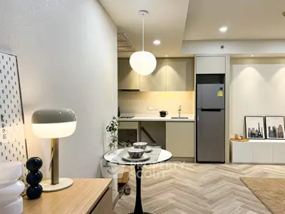 Modern open-layout kitchen with stylish lighting and sleek appliances in a contemporary apartment.