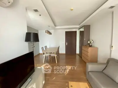 Spacious living room with modern furniture and wooden flooring.