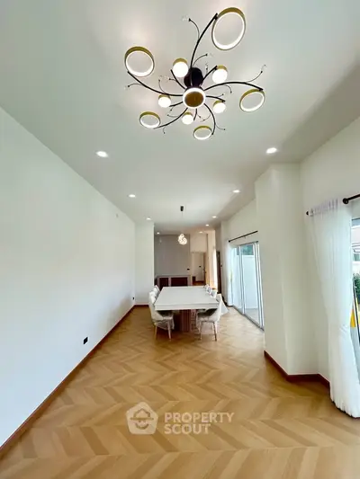 Spacious modern dining area with elegant chandelier and natural light