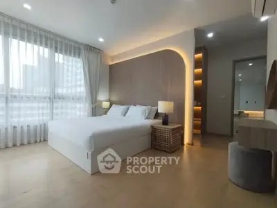 Spacious modern bedroom with elegant lighting and large windows