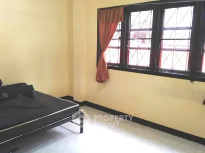 Spacious bedroom with large windows and natural light, perfect for cozy living.