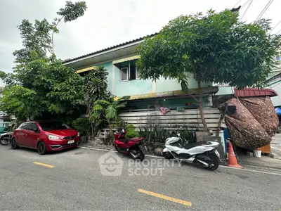 Charming residential house with lush greenery and street parking in a serene neighborhood.