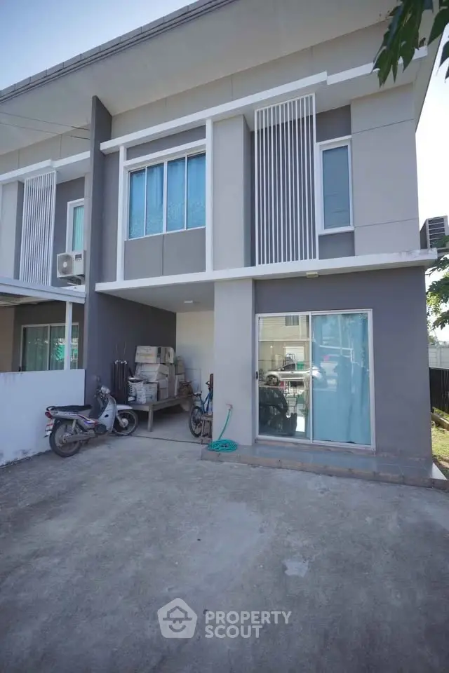 Modern two-story townhouse with sleek facade and spacious driveway