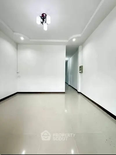 Spacious empty room with modern lighting and glossy tiled floor, perfect for customization.