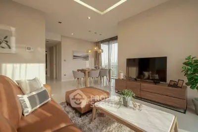 Modern living room with stylish decor and natural light, featuring a cozy seating area and dining space.