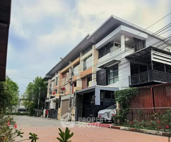 Modern townhouse exterior with sleek design and spacious driveway in a serene neighborhood.