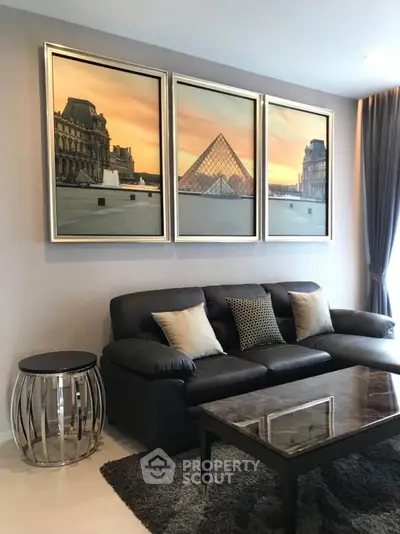 Stylish living room with elegant decor and modern furniture, featuring a chic black sofa and artistic wall art.