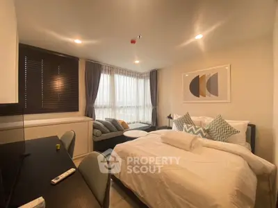 Modern bedroom with stylish decor and large window offering natural light.