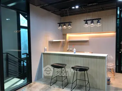 Modern kitchen with sleek bar counter and stylish lighting in contemporary home
