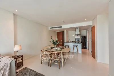 Spacious open-plan living and dining area with modern kitchen in luxury apartment.
