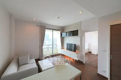 Modern living room with city view and sleek furniture in high-rise apartment.