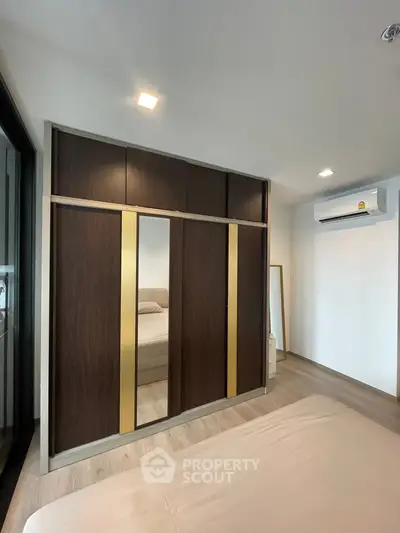 Modern bedroom with sleek built-in wardrobe and air conditioning unit