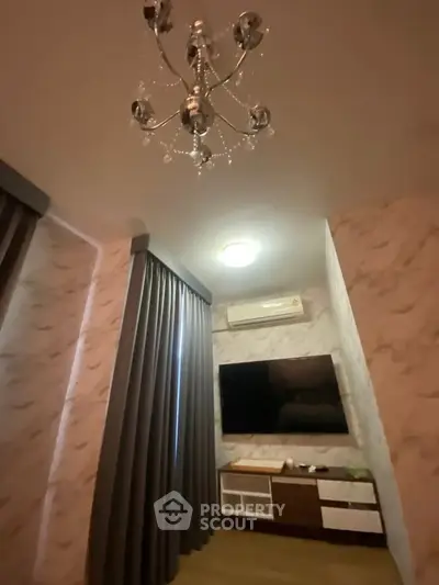 Elegant living room with modern chandelier and wall-mounted TV