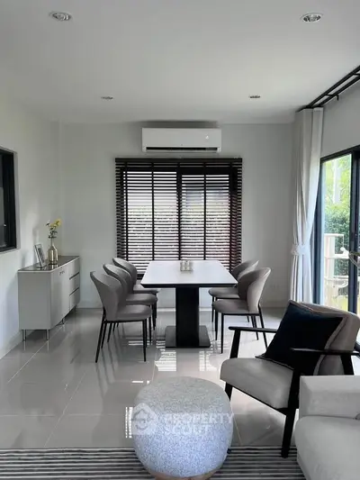 Modern dining area with sleek furniture and large windows for natural light.