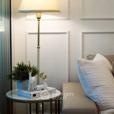 Elegant living room corner with cozy sofa, stylish lamp, and decorative accents for a serene ambiance.