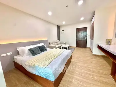 Spacious modern bedroom with cozy seating area and stylish decor