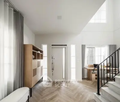 Spacious modern living room with elegant staircase and natural light