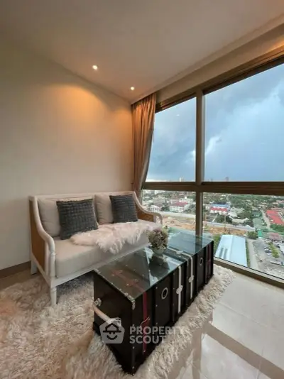 Chic living room with panoramic city view, elegant sofa, and stylish decor in modern apartment.