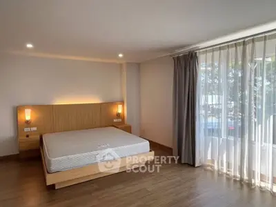 Spacious bedroom with large window and modern lighting in a stylish apartment