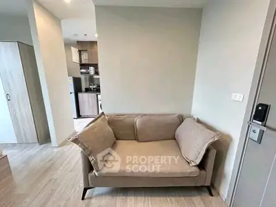 Modern living room with cozy sofa and open kitchen layout in stylish apartment.
