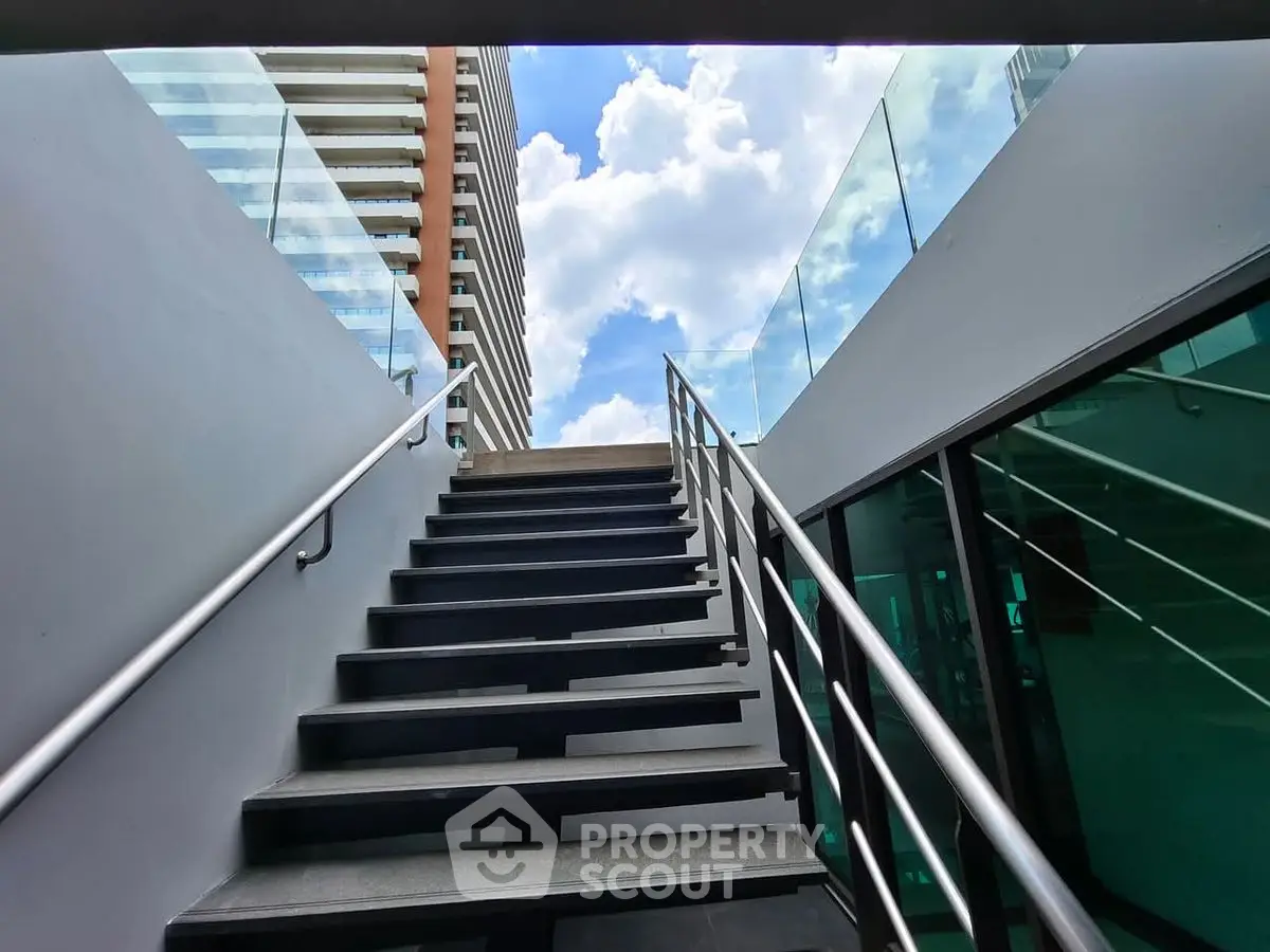 Modern rooftop access with sleek glass railings and cityscape view