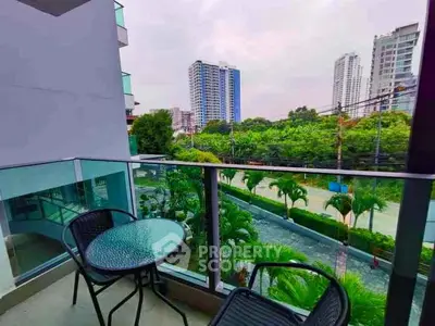 Modern balcony with glass railing offering a stunning city view, perfect for relaxation.