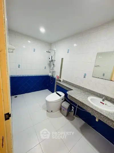 Spacious bathroom with modern fixtures and blue tile accents