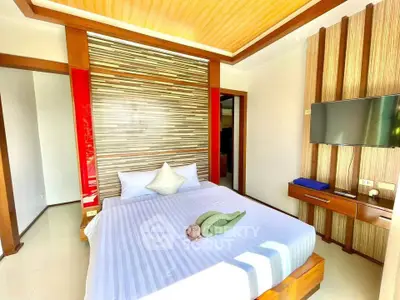 Luxurious bedroom with modern decor and wall-mounted TV in a stylish real estate property.