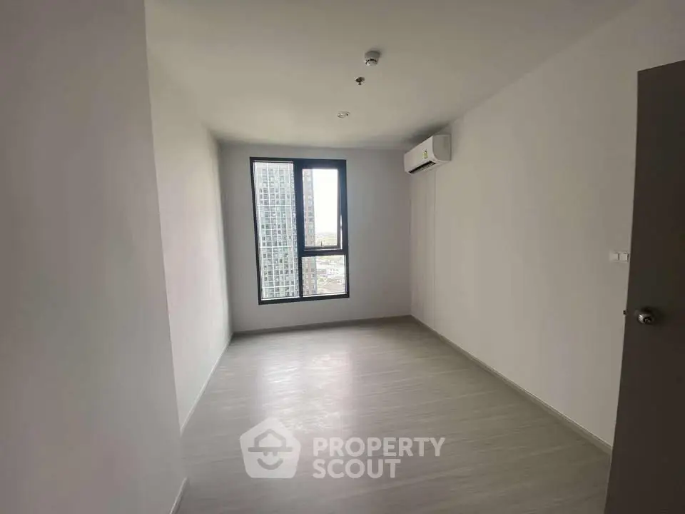 Spacious empty room with large window and air conditioning in modern apartment.