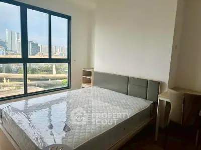 Modern bedroom with large window offering stunning city view, featuring a sleek bed and minimalist decor.