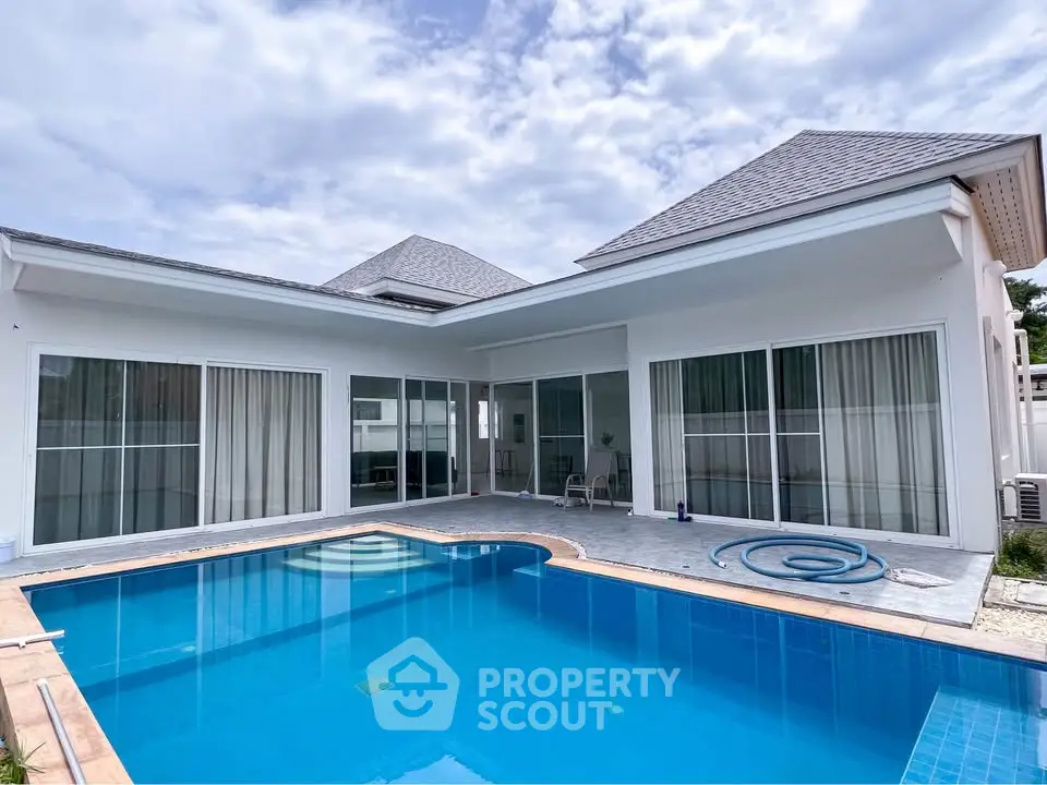Stunning modern villa with private pool and spacious patio under a clear blue sky.