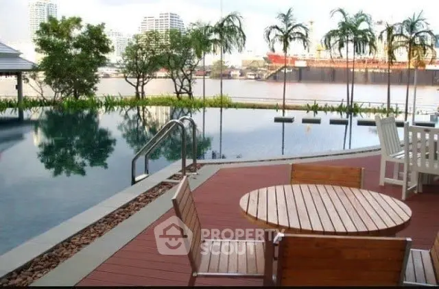 Luxurious riverside pool area with wooden deck and seating, offering stunning cityscape views.