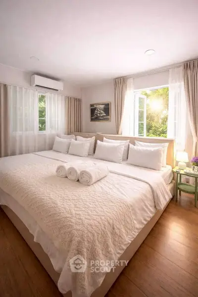 Spacious bedroom with large bed and natural light, perfect for relaxation.