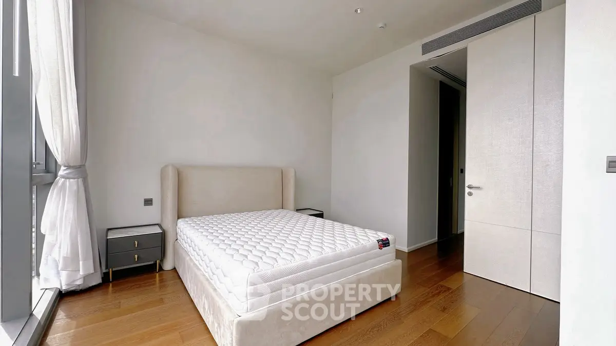 Spacious bedroom with modern design and large windows for natural light.