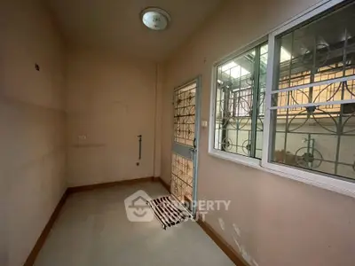 Cozy utility room with window and secure door, ideal for storage or laundry area.