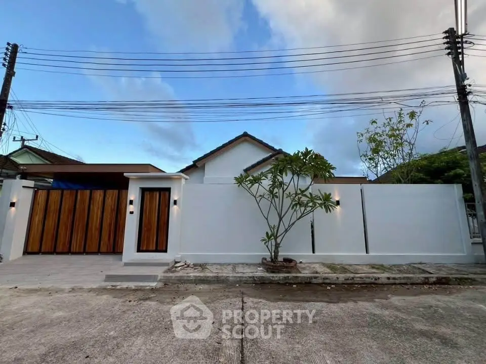 Modern minimalist house exterior with sleek white walls and wooden gate